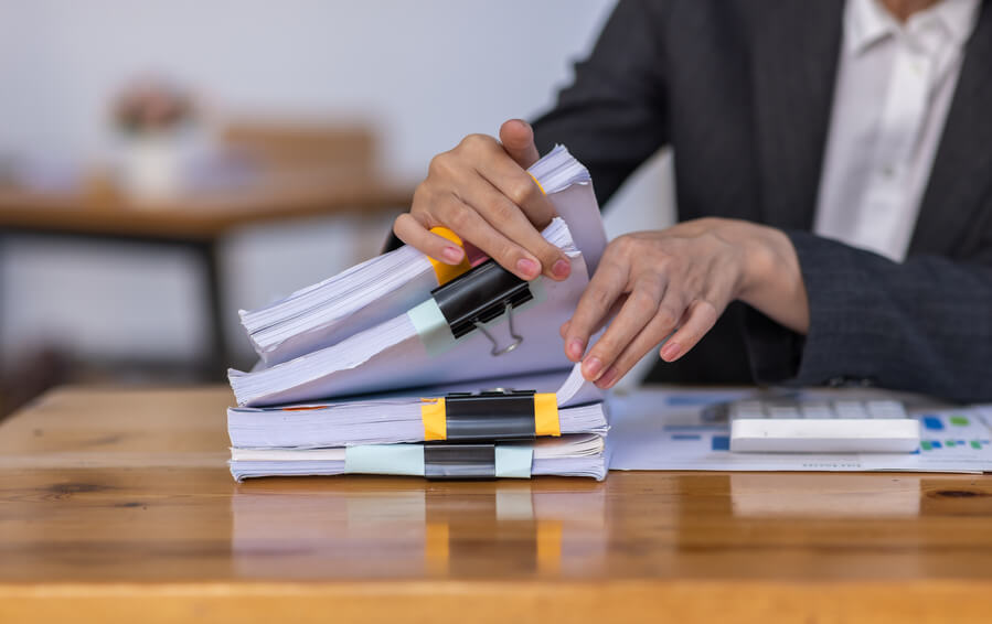 Persoon die rustig aan tafel zit met financiële documenten en een laptop